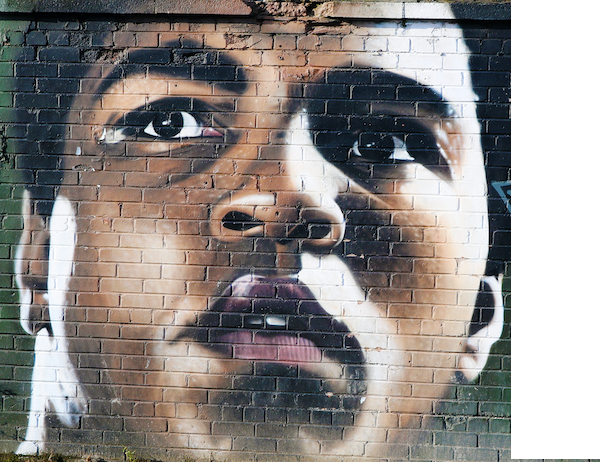 painting of Muhammad Ali on brick wall; Ali is a master of self-monitoring, a skill that can be applied to safety leadership