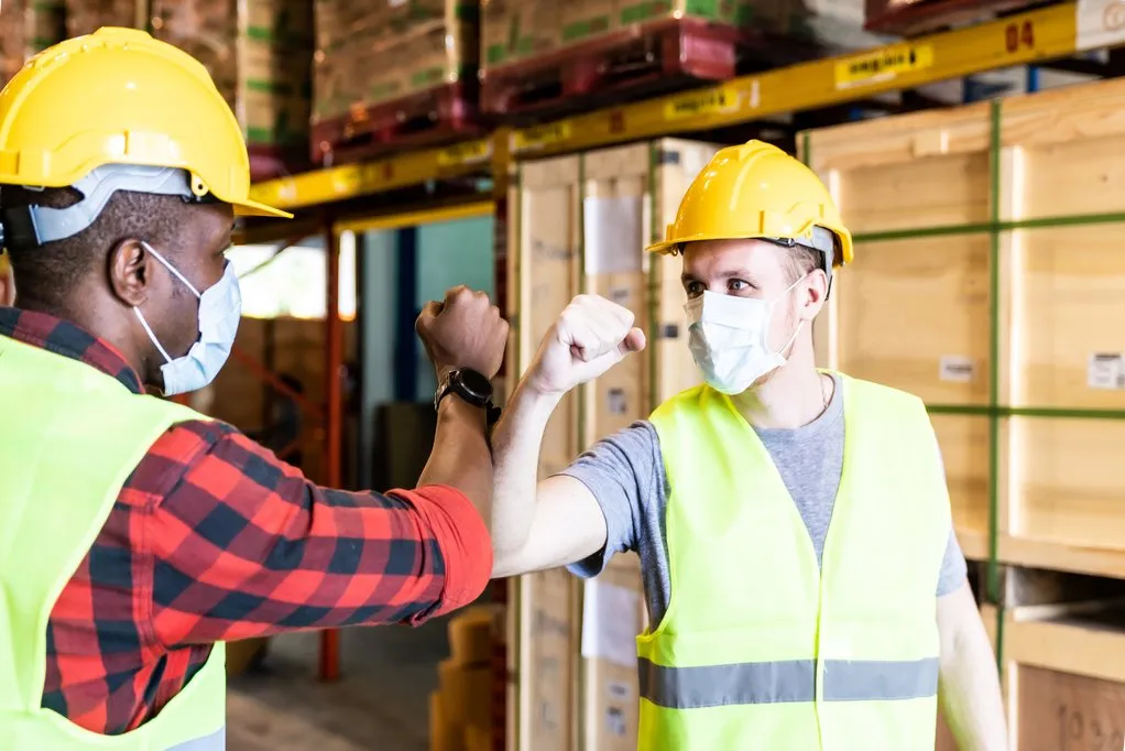 two construction workers bumping elbows because they prevented eroded skills from causing injuries after covid