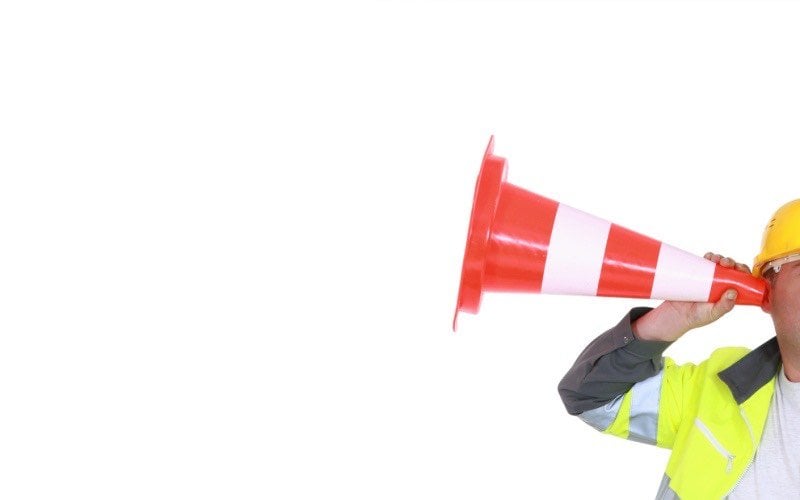 man using safety cone as a hearing aid; listening tours are a powerful tool for safety leadership